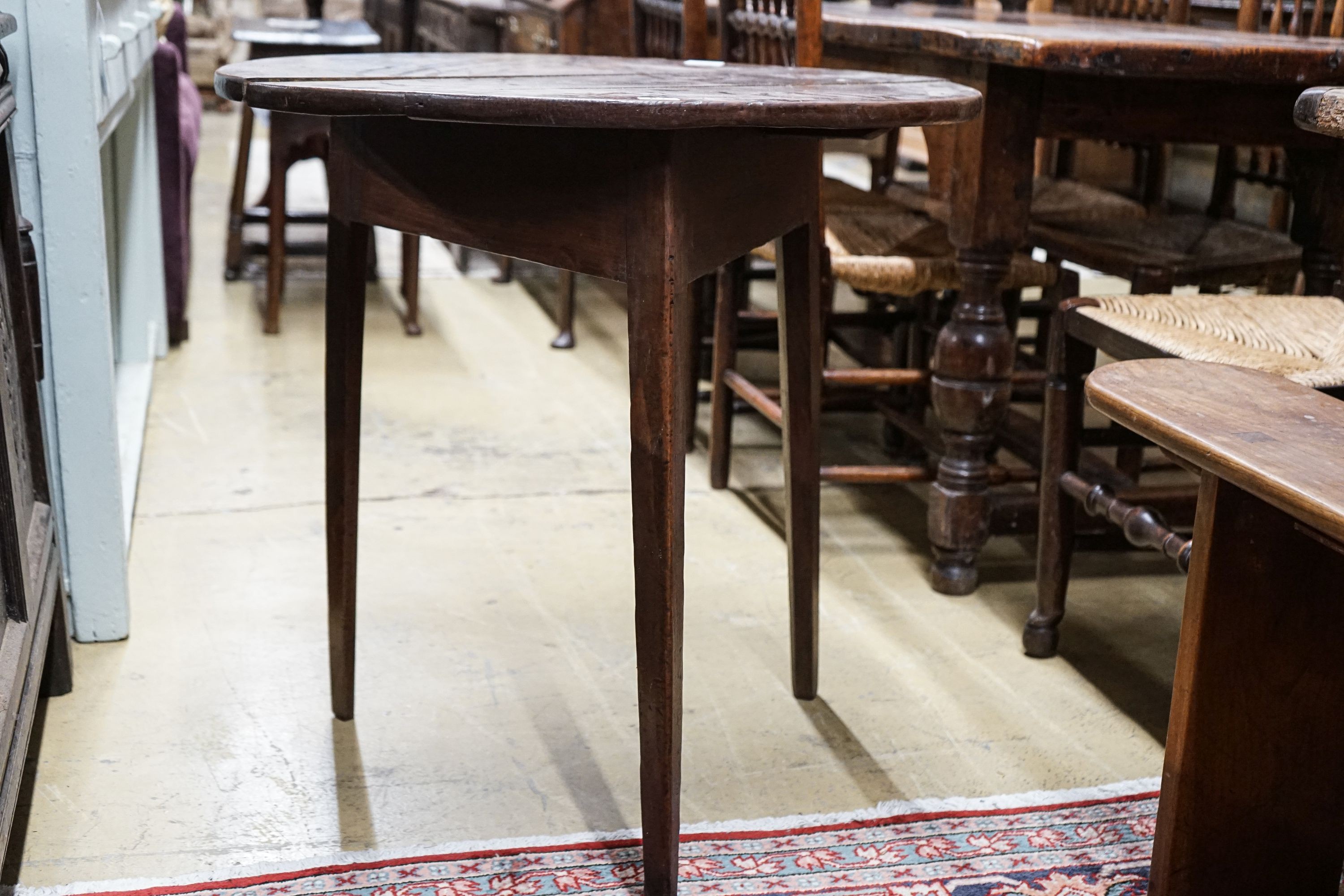 A George III oak cricket table, with circular top on tapered triangular legs, diameter 71cm height 72cm
